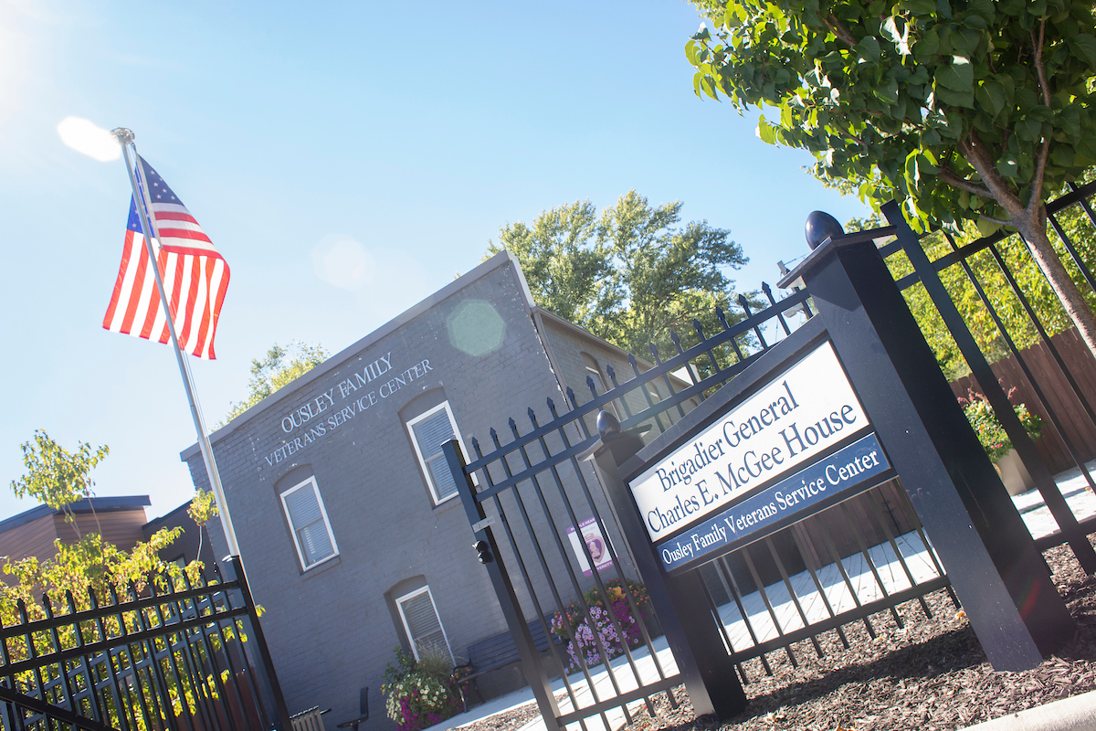 Picture of the McGee House, a grey building with the American flag flying in the front lawn