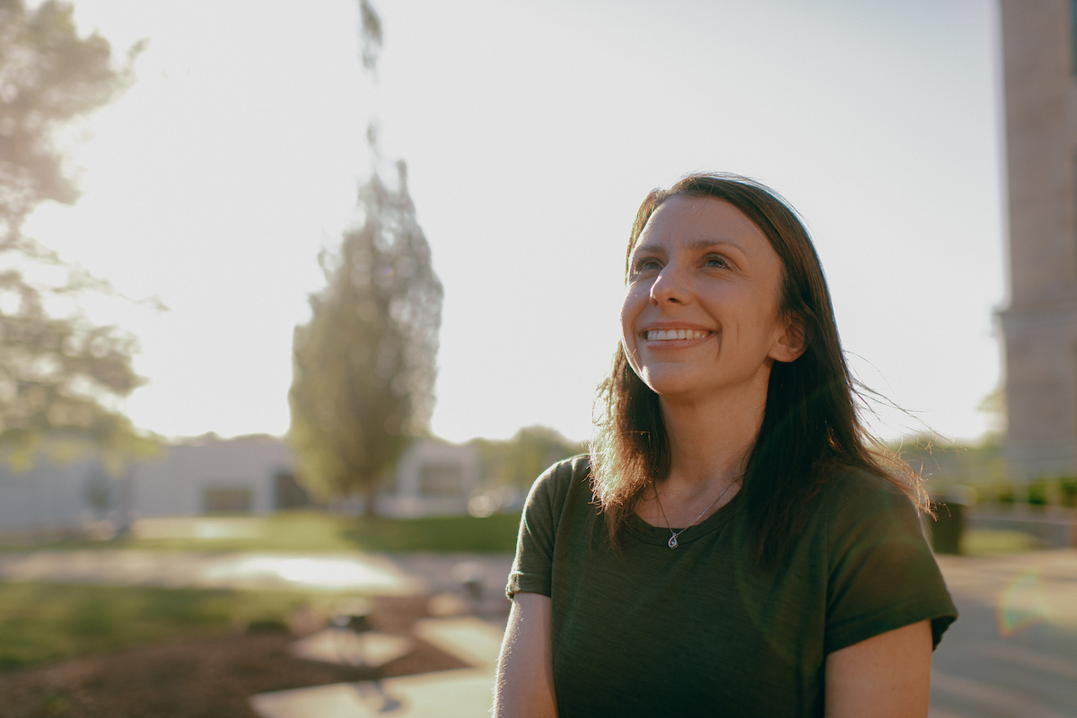 Transfer: Woman with brown hair smiling as she looks up to the sky.