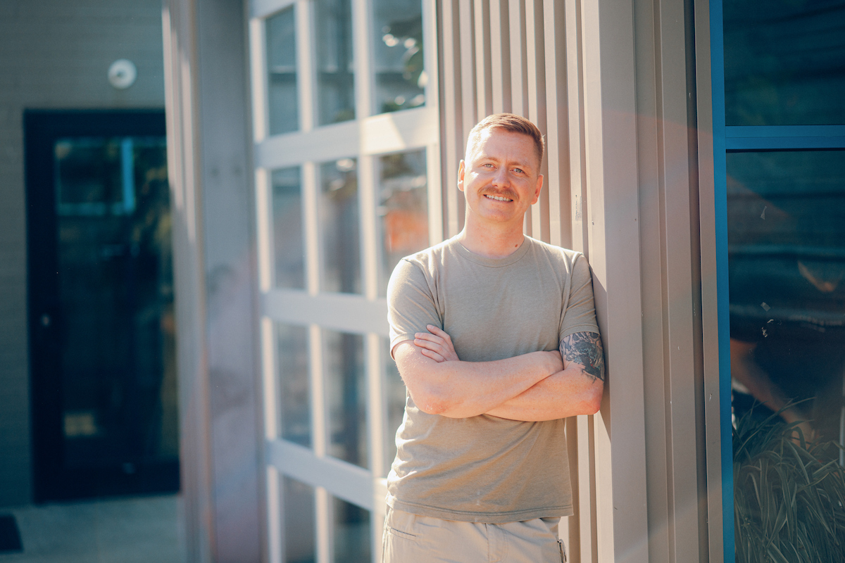 Man with arms crossed wearing military t-shirt.